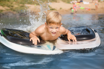 Little boy with surfboard having fun. Vacation, summer and childhood concept