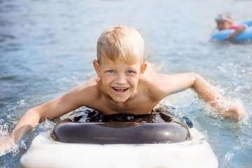 Little boy with surfboard having fun. Vacation, summer and childhood concept