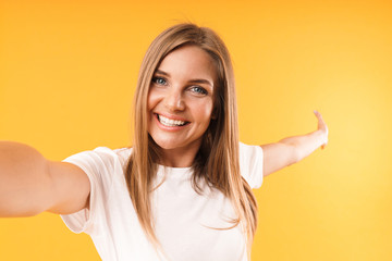 Image closeup of joyful blond woman smiling at camera while taking selfie photo