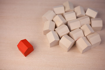 Single red wood house near of many wooden house.  Red wooden house standing out from the crowd