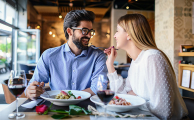 Paste and red wine. Young couple enjoying lunch in the restaurant. Lifestyle, love, relationships, food concept