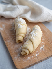 Two blanks for croissants, beautiful pretzels on a wooden Board, beautiful runner, linen towel, on gray concrete background.