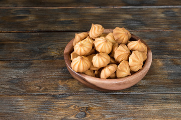 Butter cookies in a wooden bowl on a wooden table
