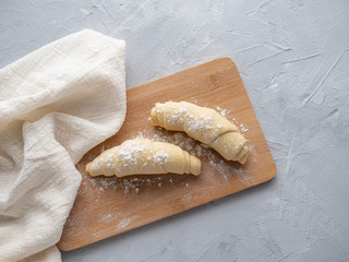 Two blanks for croissants, beautiful pretzels on a wooden Board, beautiful runner, linen towel, on gray concrete background.