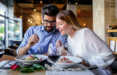Paste and red wine. Young couple enjoying lunch in the restaurant. Lifestyle, love, relationships, food concept - Powered by Adobe