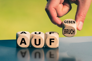 Hand dreht einen Würfel und ändert das Wort 