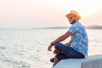 Young man enjoying sunset by the sea