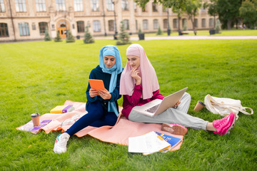 Muslim women smiling having video chat with friend