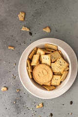 Thin crispy wholegrain crackers with seeds on grey concrete background. 