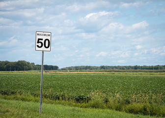 Countryfield speed limit sign on the road. Countryside. Limite de vitesse sur la route avec champ derri&egrave;re