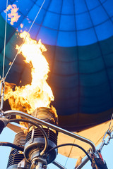 Heated air in a balloon using a burner fire.