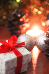 christmas gift box with red bow and candles with new year decor
