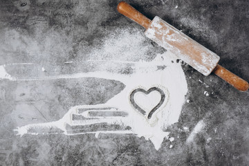 Baking background. Heart of flour and rolling pin on gray table. Bake menu, recipe, homemade pastry concept. Top view. Banner with copy space for your text. Valentine's Day