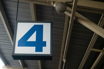 Number 4 display on hanging billboard or light box showcase on wall at airport or subway train platform station, signboard, transportation, advertisement, commercial and marketing concept