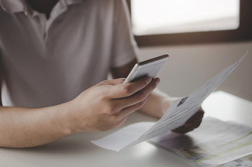 hands of young man using mobile smart phone for scan and payment online with family budget cost...