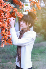 An Asian girl with hair bun and flowers.