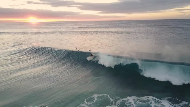 Young Man Surfing A Big Wave At Sunset From A Tropical Beach