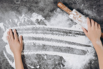 Baking background. Heart of flour, rolling pin and female hands on gray table. Bake menu, recipe, homemade pastry concept. Top view. Banner with copy space for your text. Valentine's Day