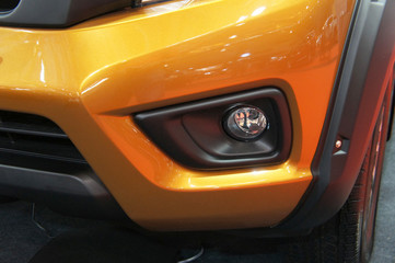 Fototapeta premium Close up of modern car front spotlight with futuristic design. Designed specifically to give more visual for the driver at night after the car head lamp. 
