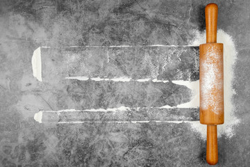 Baking flat lay with rolling pin, flour on gray background. Bake menu, recipe, homemade pastry concept. Top view, with copy space for your text.