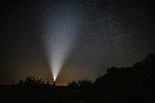 Man with flashlight enjoys the beauty of nature - Powered by Adobe