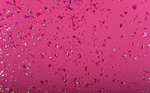 Pink confetti glitter sequins on pink background, top view