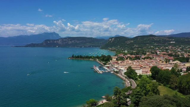 Aerial video with drone. Beautiful coastline. In the city of Bardolino, Lake Garda is the north of Italy. View by Drone. Docked yachts parking in Port.