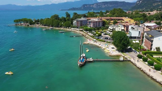 Aerial video with drone. Beautiful coastline. In the city of Bardolino, Lake Garda is the north of Italy. View by Drone. Docked yachts parking in Port.