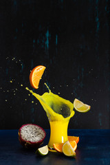Tropical splash and drops in a glass of citrus on a dark background
