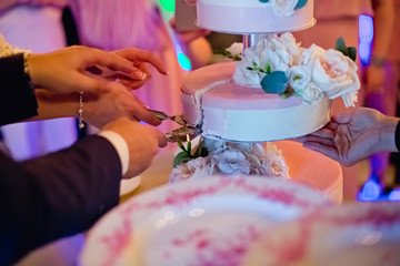 Obraz na płótnie Canvas cutting the wedding cake by the bride and groom