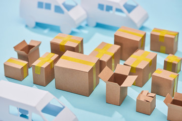 cardboard boxes near white vans on blue background with copy space