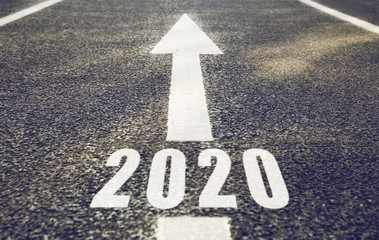 future, new beginning and destination concept - white road marking in form of 2020 year and arrow