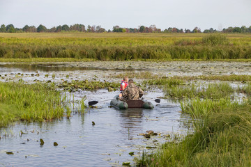 Fototapeta na wymiar Fishermen in a boat swim in a pond