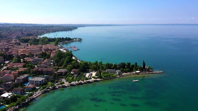 Aerial video with drone. Beautiful coastline. In the city of Bardolino, Lake Garda is the north of Italy. View by Drone. Docked yachts parking in Port.