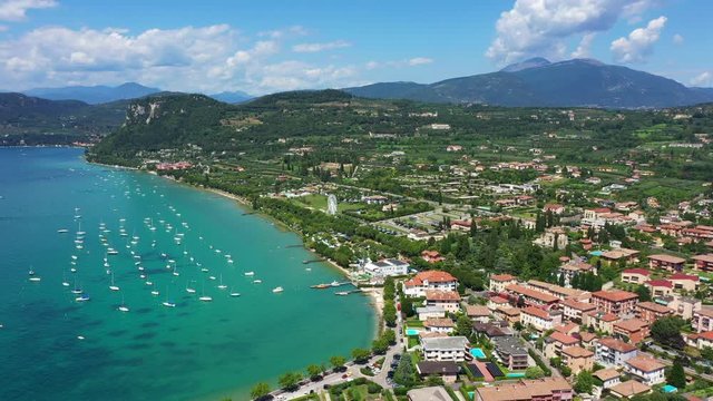 Aerial video with drone. Beautiful coastline. In the city of Bardolino, Lake Garda is the north of Italy. View by Drone. Docked yachts parking in Port.