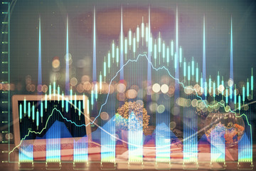 Double exposure of chart and financial info and work space with computer background. Concept of...