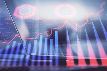 Forex graph hologram on table with computer background. Multi exposure. Concept of financial markets.