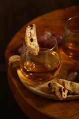 dessert white wine and biscotti on a wooden table