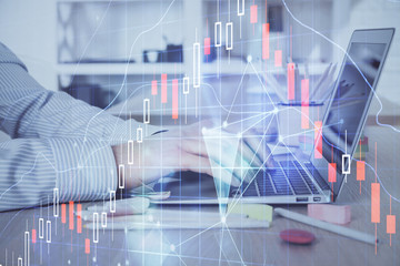Double exposure of stock market graph with man working on laptop on background. Concept of financial analysis.