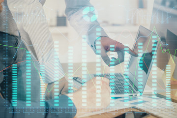 Double exposure of chart with businessman typing on computer in office on background. Concept of hard work.