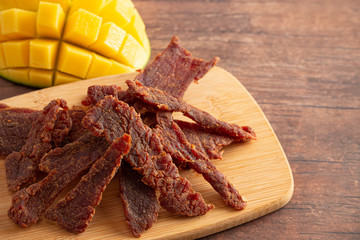 Gourmet Sweet Mango Flavored Beef Jerky on a Cutting Board