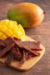 Gourmet Sweet Mango Flavored Beef Jerky on a Cutting Board