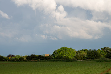 Storm clouds building over green fields and trees on a summer day in the countryside near Shenington, Oxfordshire