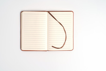 top view blank orange leather diary on white desk