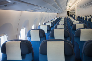 An economy class empty cabin of the airplane - empty blue chairs