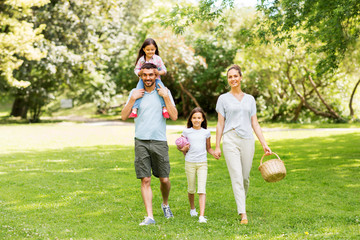 family, leisure and people concept - happy mother with picnic basket, father and two daughters...