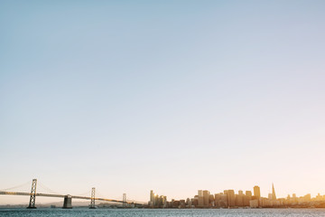 Panoramic view of San Francisco, California skyline with Bay Bridge at sunset