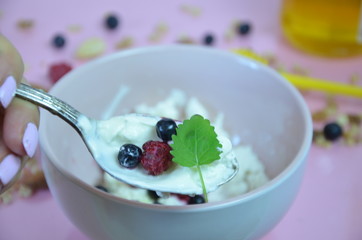 Ricotta with fresh berries and honey on pink table. Cottage cheese, curd cheese or tvorog with berries in bowl. Summer dessert, breakfast or healthy snack. jar of honey blueberries and raspberries