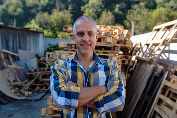 a carpenter repairs wooden pallets