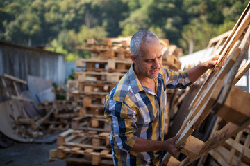 Fototapeta na wymiar a carpenter repairs wooden pallets